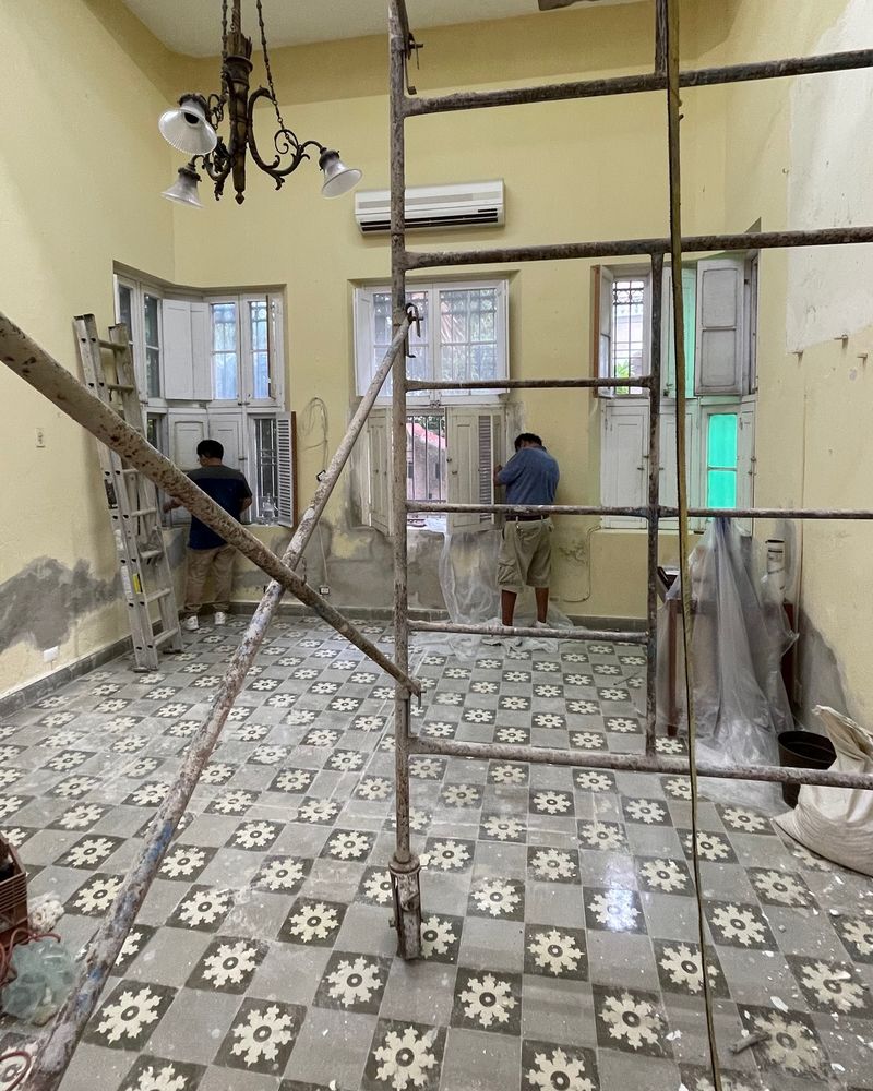 Obra en proceso con andamio en un salón de techo alto